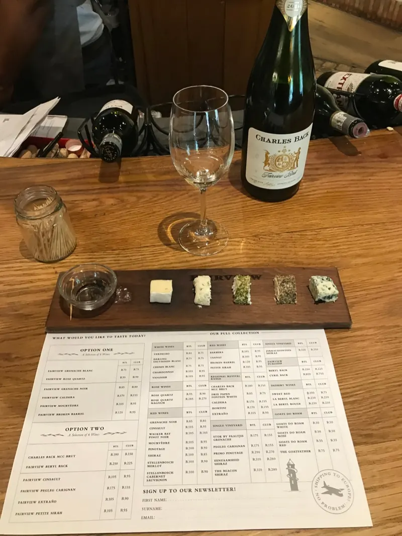 A cheese and wine pairing board with tasting notes on a wooden table