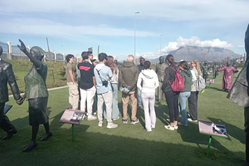 A tour group among the bronze freedom-march statues with Table Mountain behind
